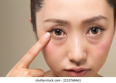 A woman pointing to her eyes. - Shutterstock ID 2213768461