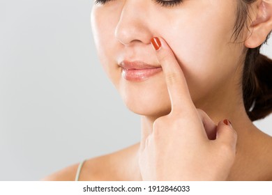 A Woman Is Pointing At Her Nose.