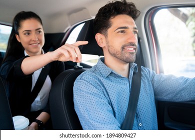 Woman pointing something to her taxi driver.