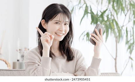 A woman pointing at something while using her smartphone