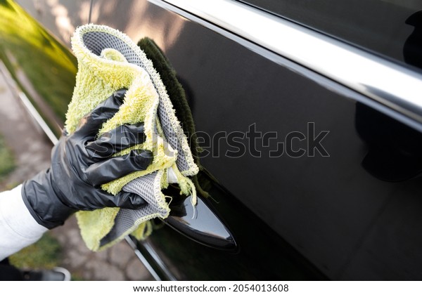 woman polishes the car, uses a
microfiber cloth and polish to wipe the car's body with
polish.