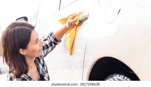 Woman Polishing Car Door Handle With Microfiber Rag