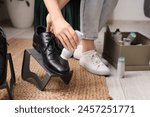 Woman polishing leather male shoes at home, closeup