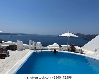 Woman in pool Santorini Greece cliffside caldera view - Powered by Shutterstock