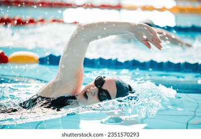 Woman, pool and swimming in water for sports fitness, exercise or training in olympic or athletics. Female person, athlete or professional swimmer in competition, race or marathon in workout practice - Powered by Shutterstock