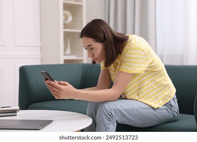Woman with poor posture using smartphone at home