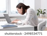 Woman with poor posture working in office