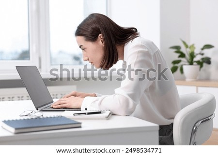 Woman with poor posture working in office