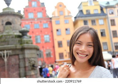 Woman portrait in Europe, Stortorget, Stockholm, Sweden. Happy candid travel tourist girl on big square in Gamla Stan, the old town of Stockholm, Sweden.