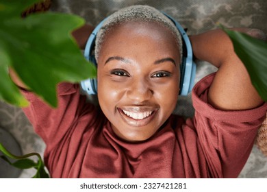 Woman, portrait and headphones for listening to music to relax with plants for peace and calm. Face of a happy black female person streaming sound, audio and podcast or radio online at home - Shutterstock ID 2327421281