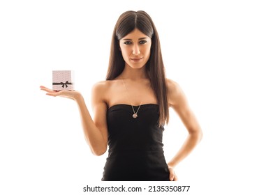 Woman portrait holding and showing  cardboard present against white background. 