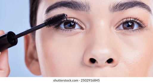 Woman, portrait and mascara tool in studio for eyelash treatment, application and blue background. Female person, cosmetic brush and skincare for makeup product, cosmetics and hydration for lashes