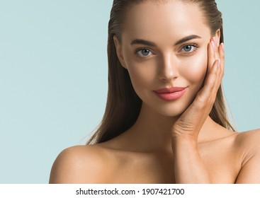 Woman portrait skin care long beauty brunette hair hand manicure touching face blue background