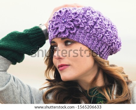 Woman posing in handmade knitted purple hat