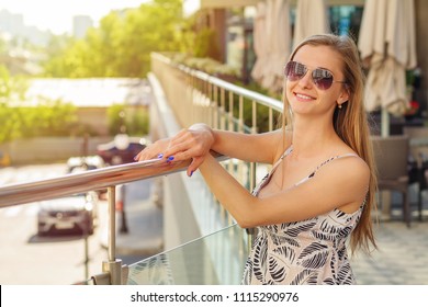 Woman posing on the terrace, view of the city. Outdoor portrait, close up.