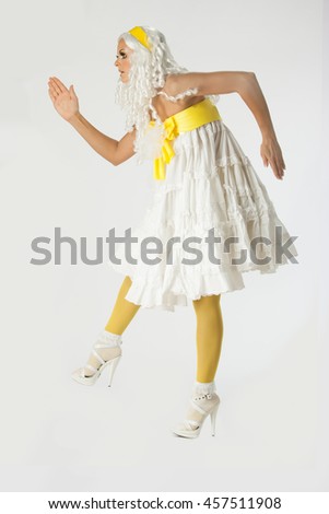 
Woman posing as a plastic Barbie doll on a white background