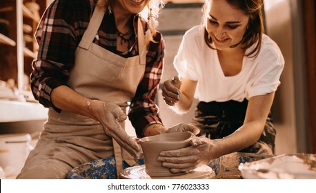 Woman Potter Teaching The Art Of Pot Making. Women Working On Potters Wheel Making Clay Objects.