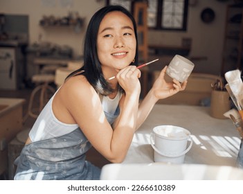 Woman, potter or thinking of product design ideas, cup painting vision or creative color in Asian pottery studio. Smile, happy or clay store worker and mug goals, small business or ceramic workshop - Powered by Shutterstock