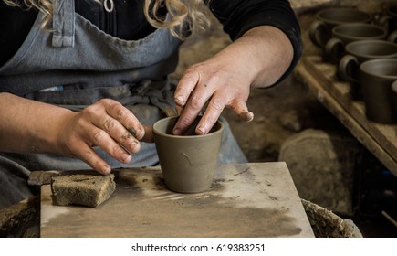 Woman potter at work creating some traditional cups of white clay, Margarites, Rethimno, Crete. 