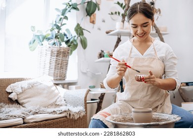 Woman at pottery class teaches to decorate ceramic jug - Powered by Shutterstock