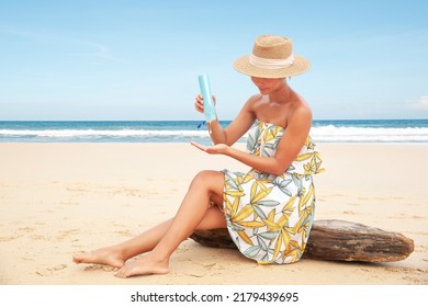 Woman Pouring Applying Sunblock Cream Lotion On Beach For Broad Spectrum UVA, UVB Sun Protection