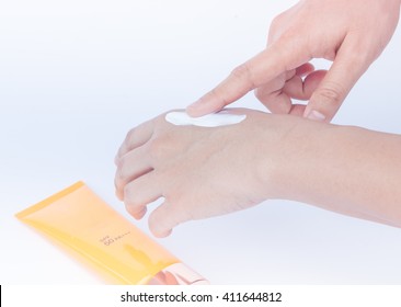 Woman Pouring Body Lotion On Hand On White Background