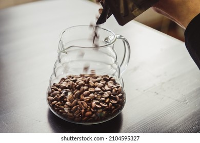 Woman Pouring Coffee Beans Into Vintage Grinder At Countertop Indoors, Closeup.