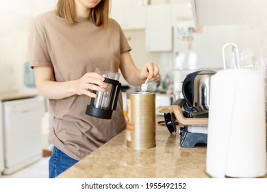 Woman pouring coffee in two coffee cups at morning. Girl put coffe in french press coffee maker.Close up - Powered by Shutterstock