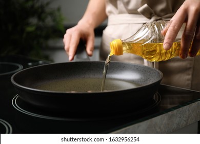 Woman Pouring Cooking Oil From Bottle Into Frying Pan, Closeup