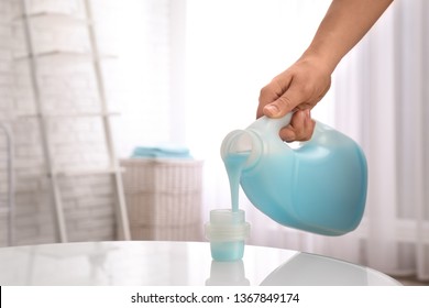 Woman pouring detergent into cap on table indoors, closeup with space for text. Laundry day - Shutterstock ID 1367849174