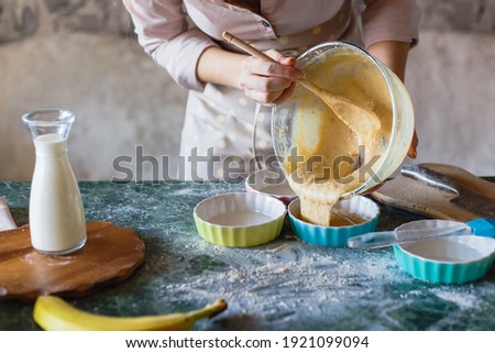Woman pouring dough from bowl into baking mould for pie