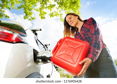 Woman Pouring Fuel Into Gas Tank Of A Car From Can