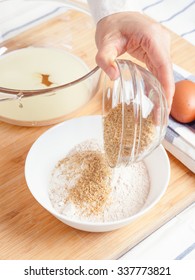 Woman Pouring Ground Flaxseed Into Flour With Baking Ingredients For Healthy Muffins