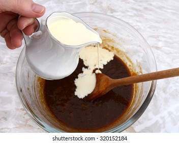Woman Pouring Heavy Cream From A Jug Into Pumpkin Pie Filling In A Bowl