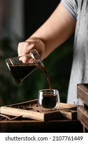 Woman Pouring Hot Turkish Coffee Into Glass Cup At Table, Closeup