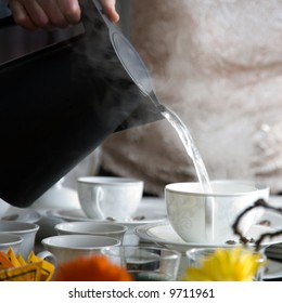 Woman Pouring Hot Water To Fancy Tea Cups