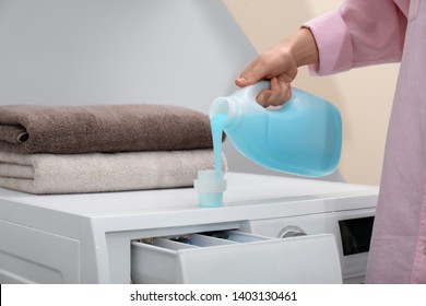 Woman Pouring Laundry Detergent Into Cap On Washing Machine Indoors, Closeup