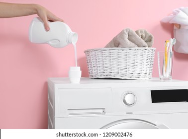 Woman pouring liquid detergent into cap on washing machine in laundry room, closeup - Shutterstock ID 1209002476