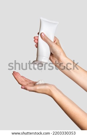 Woman pouring lotion into hand. Cosmetic product branding mockup. Daily skincare and body care routine. Female hand holding  cosmetic product mockup, close up. 