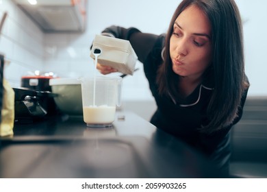 Woman Pouring Milk in a Measuring Cup. Perfectionist home cook measures liquid quantity with a graduated cup
