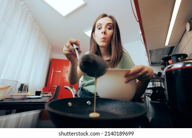 
Woman Pouring Pancake Mix Into The Pan Sited On The Induction Hob. Concerned Home Cook With Attention To Detail Preparing Homemade Crepes For Breakfast
