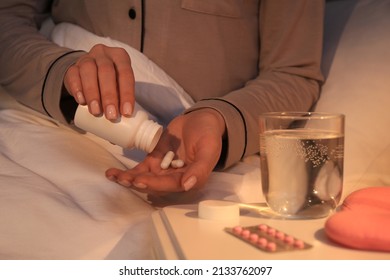 Woman Pouring Pills From Bottle Into Hand Indoors, Closeup. Insomnia Treatment