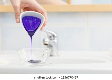 Woman Pouring Purple Hair Dye Or Shampoo Toner Into White Bowl. Hygiene Object Concept.