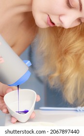 Woman Pouring Purple Hair Dye Or Shampoo Toner Into White Bowl. Hygiene Object Concept.