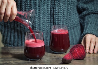 Woman Pouring Self Made Beet Juice In Glass 