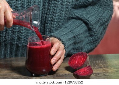 Woman Pouring Self Made Beet Juice In Glass 