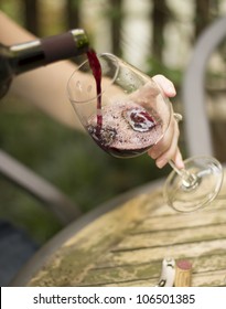 A Woman Pouring Some Wine Into A Glass