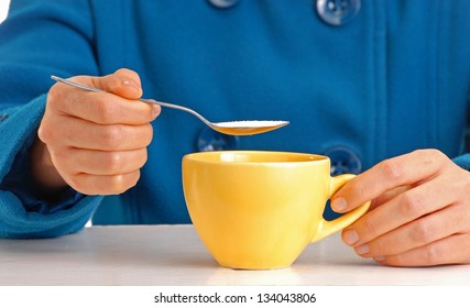 Woman Pouring Sugar On Coffee Cup.