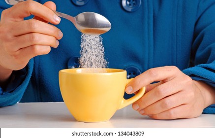 Woman Pouring Sugar On Coffee Cup.