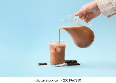 Woman Pouring Tasty Chocolate Milk From Jug Into Glass On Color Background